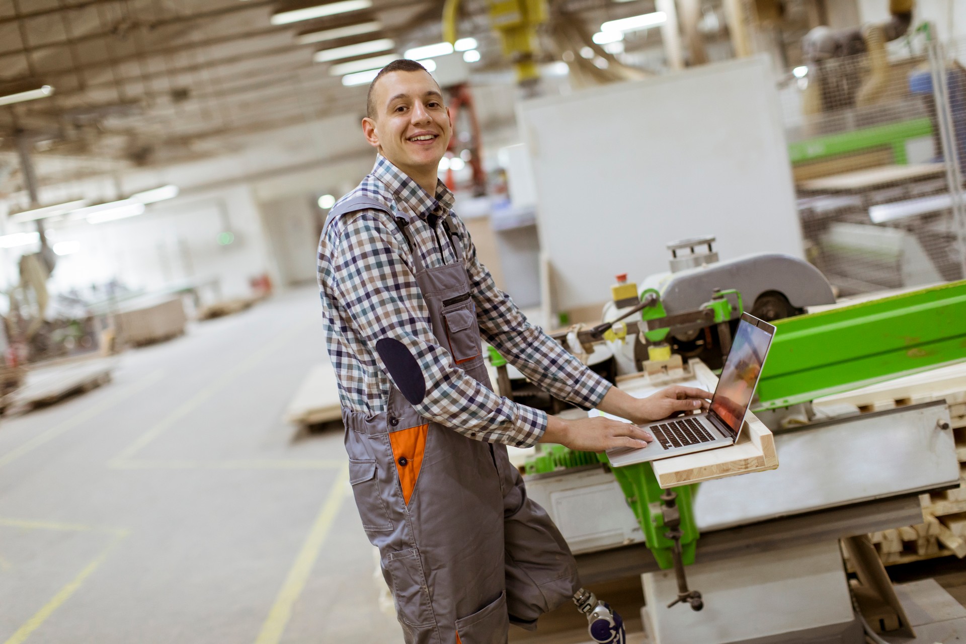 Disabled young man with an artificial leg is working at the furniture  factory